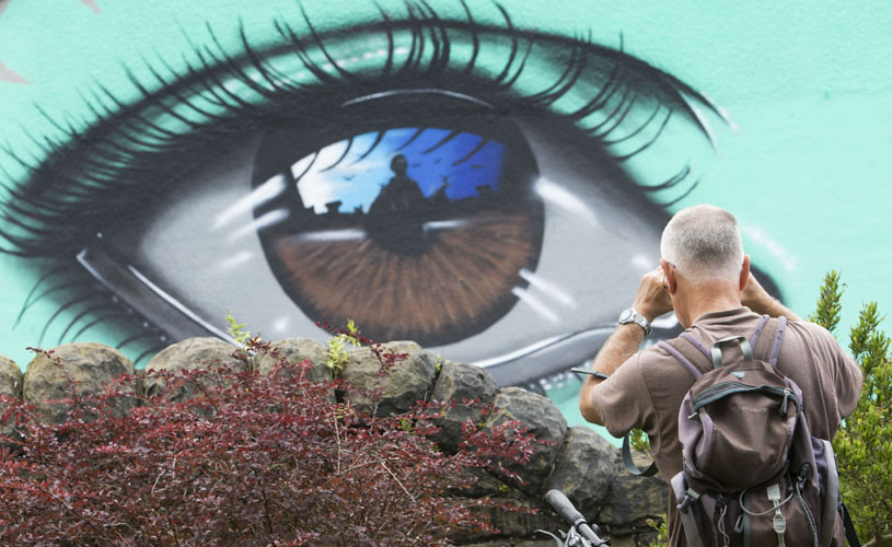 Man taking a photo of an eye mural - street art in Bedminster